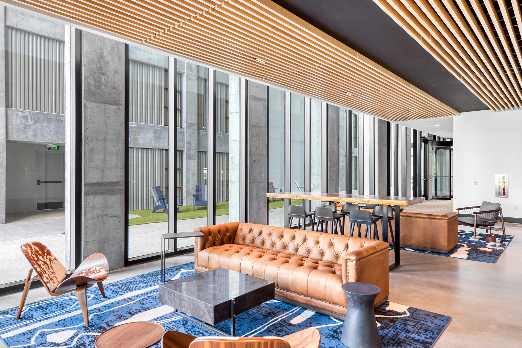 Collaborative space with couch, chairs, and table seating overlooking the outdoor breezeway entry to Science Square Labs